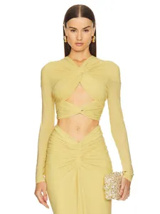Close-up of elegant pale yellow long-sleeved twist front crop top with ruched skirt details.