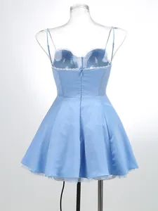 Back view of a blue strappy mini dress with lace trim and pleated skirt on a mannequin.