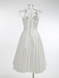 Vista posteriore di elegante abito midi bianco allacciato al collo con pieghe