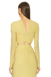 Detailed back view of yellow ruched long-sleeved crop top and matching slim-fit skirt