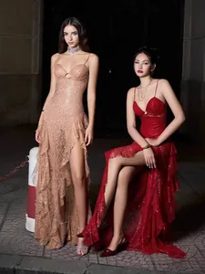Detailed view of two elegant high-slit evening dresses with spaghetti straps and ruffles.
