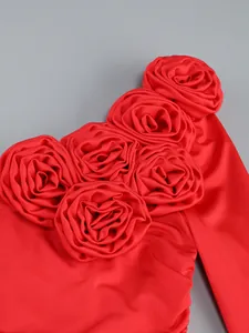 Close-up detail of red evening dress with 3D fabric roses and ruched texture design