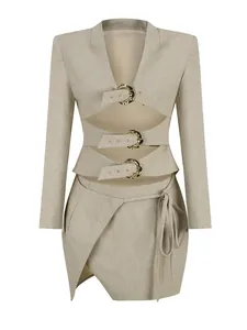 Front view detail of beige two-piece set with hollow-out jacket and gold buckles