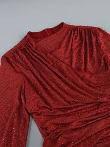 Detailed close-up of red rhinestone dress showing the draped neckline and fabric texture