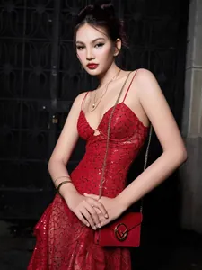 Detailed view of elegant red sequined lace dress with deep V-neck and high slit detail