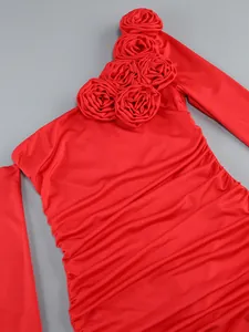 Detailed macro view of red ruched dress featuring elegant 3D flower applique