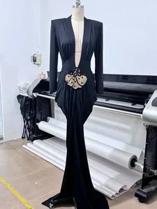Elegant black long-sleeved evening gown with deep V-neck and sequined butterfly detail.
