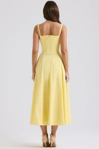 Vista posteriore dettagliata di un top a corsetto giallo e set di gonna midi coordinata
