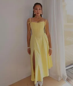 Vista a figura intera di un abito a corsetto giallo con stecche e spacco laterale