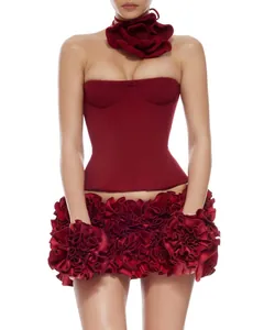Dettaglio di un elegante abito a corsetto bordeaux con gonna a balze floreali e choker