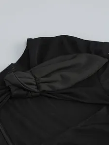 Detailed view showing the elegant twisted knot on black sheer mesh evening dress fabric