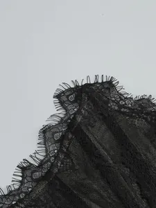 Detailed close-up showing the intricate texture of black eyelash lace evening gown fabric