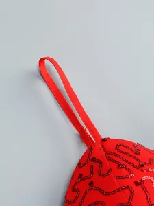Close-up macro detail of red mesh strap with sequin embroidery on high-end sexy evening dress