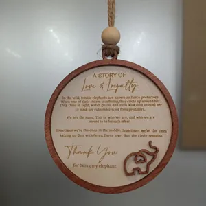Détail d'un pendentif en bois avec texte d'amitié gravé et charm d'éléphant ajouré.