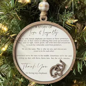 Vue détaillée d'un ornement en bois avec éléphant et poème de loyauté sur un sapin de Noël