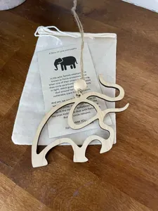 Détail de l'ornement éléphant en bois avec carte d'histoire et sac cadeau en lin