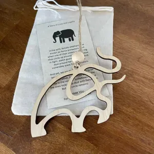 Vue détaillée d'un cadeau éléphant en bois avec une carte d'histoire sentimentale et sac