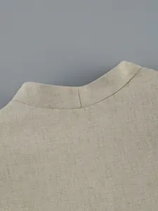 Detailed close-up view of a beige textured fabric collar on an elegant women's top.