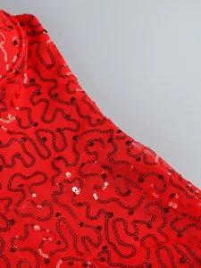 Detail shot of red sequined patterns on see-through mesh dress fabric for elegant evening wear.