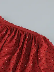 Exquisite close-up detail of a red evening dress with luxury sparkling rhinestone embellishments