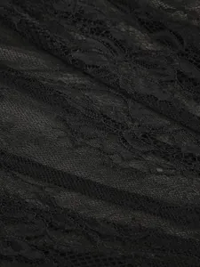 Close-up macro view of delicate black floral lace fabric with intricate embroidery details