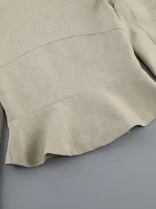 Detailed view of the elegant beige linen-blend ruffled hem on a high-end women's top