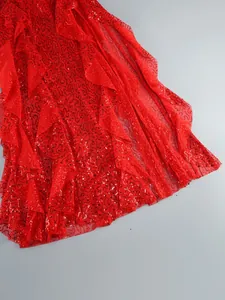 Detailed macro view of vibrant red sequined ruffles on elegant evening maxi dress fabric