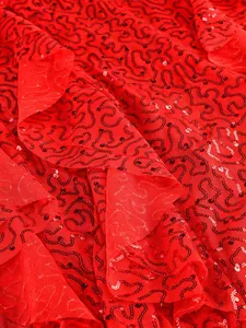 Close-up detail of red sequin wavy embroidery on sheer mesh fabric of a luxury gown