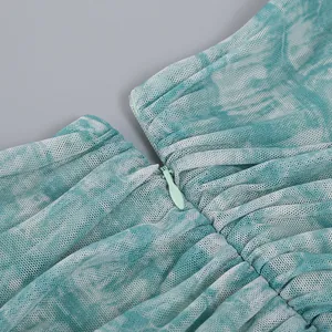 Close-up detail of back invisible zipper on a gathered teal marble print mesh dress