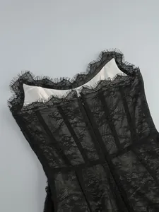 Close-up of the back zipper and delicate eyelash lace on a black corset dress.