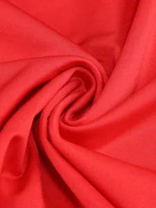 Close-up detail of vibrant red pleated satin fabric for an elegant evening dress
