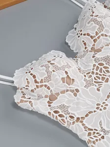 Detailed close-up of intricate white floral lace on a sophisticated bodycon dress