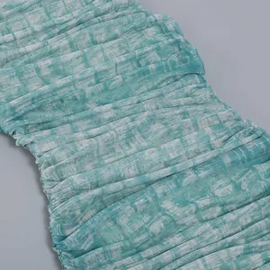 Close-up of ruched mesh fabric with green and white tie-dye print for a bodycon dress