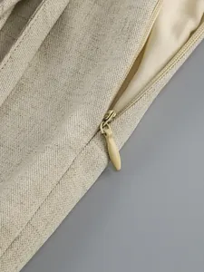 Close-up detail of a high-quality invisible zipper on beige textured fabric garment