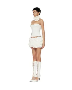 Vista laterale di una donna in abito a corsetto bianco con minigonna floreale 3D e choker