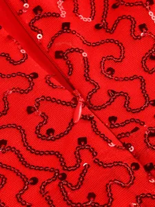 Close-up of red sequins and invisible zipper on a sheer red mesh evening dress detail.