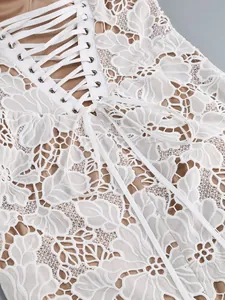Close-up view of a white floral lace dress featuring a sexy corset-style lace-up back detail.