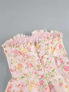 Dettaglio di abito floreale rosa senza spalline con scollatura a volant e stecche