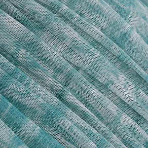 Macro detail of light green mesh fabric texture with elegant pleats and patterns.