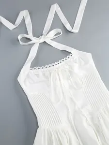 Dettaglio di un abito bianco a collo alto con pieghe e pizzo fine