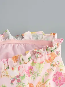 Dettaglio dello scollo a balze su un top a fascia a fiori rosa con fascia elastica
