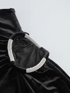 Primer plano del detalle de anillo con pedrería en vestido de fiesta de terciopelo negro