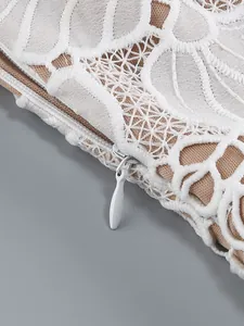 Close-up view of white floral lace jacquard pattern and hidden zipper on an elegant dress