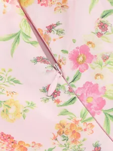 Dettaglio ravvicinato della cerniera invisibile su abito a fiori rosa con piccoli motivi