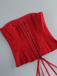 Dettaglio di un corsetto rosso senza spalline con allacciatura in raso e occhielli.