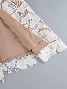 Macro detail showing the intricate white floral lace and tan lining of the elegant dress