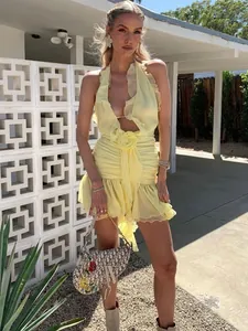 Detailed view of sexy yellow halter neck mini dress with ruffles and 3D flower decoration
