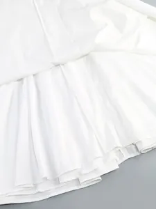 Vista macro dettagliata che mostra il fine tessuto plissettato bianco e l'orlo