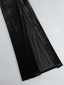 Primer plano detallado de un vestido largo de terciopelo negro con abertura lateral alta