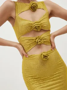 Detailaufnahme eines goldenen Glitzerkleides mit Ausschnitten und Blumenverzierungen.
